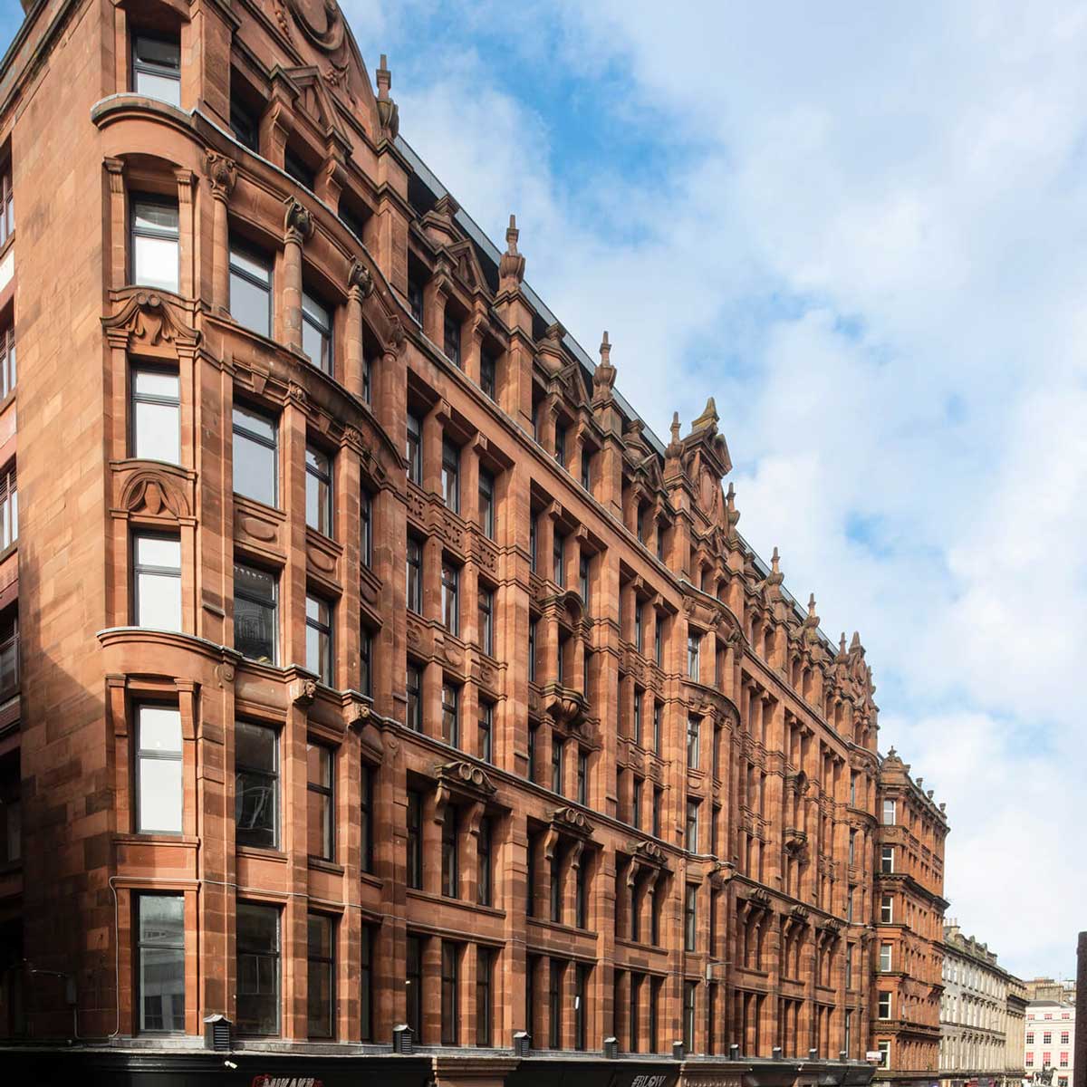 Off centre shot of the red sandstone facade while looking along Queen Street